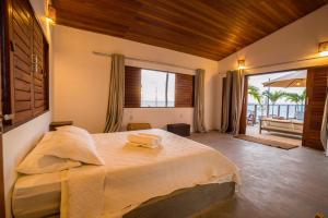 a bedroom with a large bed and a large window at Casa Galo Pretto in Galinhos