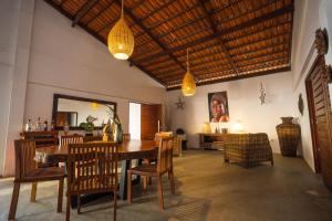 a dining room with a wooden table and chairs at Casa Galo Pretto in Galinhos