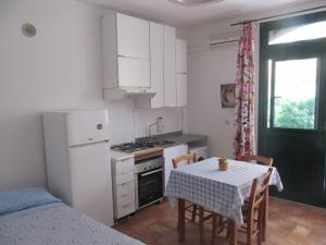 a kitchen with a table and a white refrigerator at Agriturismo Cele in Celle Ligure
