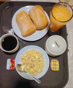 Una bandeja con dos platos de desayuno y una bebida. en Hostal Winya, en Lima