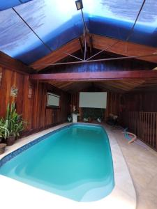 瓜拉雷马Sítio Ouro Fino Guararema的蓝色天花板房子内的游泳池