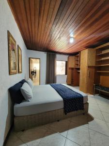 瓜拉雷马Sítio Ouro Fino Guararema的卧室里有一张大床，配有木质天花板 更多20张照片