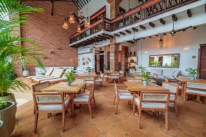 um restaurante vazio com mesas e cadeiras de madeira em Casa Linaje Hotel Boutique by HMC -Cauca Viejo- Mayores de 10 años em Jericó