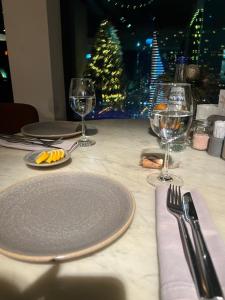 a table with a plate and two glasses of wine at Luxury South Beach Hotel in Batumi