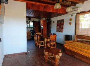 a bedroom with a bed and a table and chairs at Cabañas La Puesta del Sol in Estancia Vieja