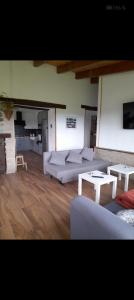 a living room with couches and tables in a room at Rural Norte in Bañugues