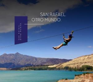 圣拉斐尔Complejo de Cabañas Quintana Cochera Cocina Wifi Smartv Aire Acondicionado的一名男子悬挂在湖面上的绳子上