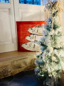 a christmas tree next to a painting of fish at acquarello in Siracusa