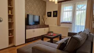 a living room with a couch and a tv at Apartmani Vukadin in Jahorina