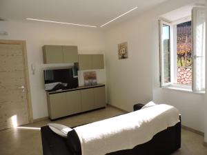 a bedroom with a bed and a tv and a window at L'Ora del Bianco in Nave San Felice +7 photos