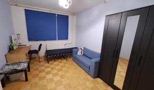 Una sala de estar con un sofá azul y una ventana. en Hubane 3-toaline korter Tondiraba Jäähalli ja pargi kõrval, en Tallin