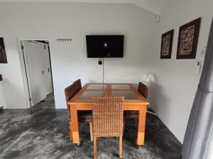 a dining room table with chairs and a television on the wall at 66onjennings Strand in Strand