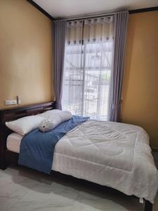 Un dormitorio con una cama grande con ventana. en My Little House in Bangkok, en Don Muang Airport