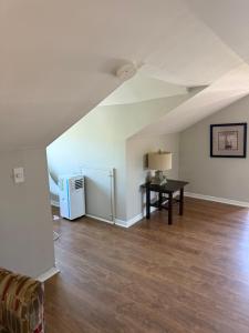 ein leeres Wohnzimmer mit einem Tisch und einem Kühlschrank in der Unterkunft Elizabeth Ave Apartments - Loft Apartment in St. John's