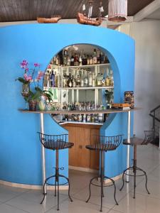 a blue bar with three stools in a room at Suíte privativa em casa compartilhada in São Paulo +1 photo