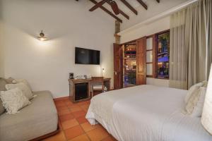 um quarto com uma cama, um sofá e uma televisão em Casa Linaje Hotel Boutique by HMC -Cauca Viejo- Mayores de 10 años em Jericó