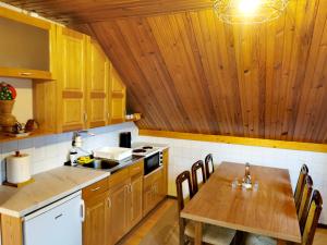 a kitchen with wooden cabinets and a wooden table at Planinski Mir in Zaovine