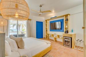 a bedroom with a white bed and a tv at Blue Reef Beach and Marina in Placencia