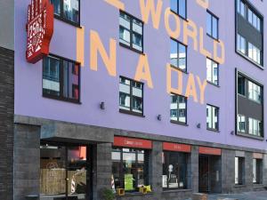 a purple building with a sign that reads world in a day at 25hours Hotel The Trip in Frankfurt +40 photos