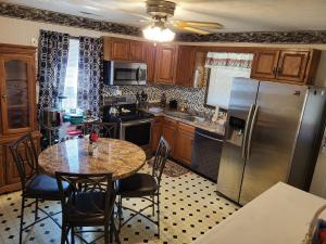 a kitchen with a table and a stainless steel refrigerator at Wildwood Estates in Lynchburg