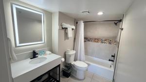 a bathroom with a sink and a toilet and a shower at Border Plaza Hotel in San Diego +62 photos