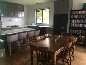 a kitchen with a wooden table and some chairs at Fortuna views farm stay in Jumbuk
