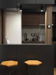 a kitchen with two wooden stools next to a counter at Vila Golija Peak Suites in Kopaonik