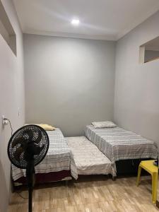 een slaapkamer met 2 aparte bedden en een ventilator bij Aconchego Paracuru in Paracuru +15 foto's