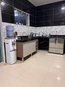 een keuken met zwart-wit betegelde muren bij Aconchego Paracuru in Paracuru