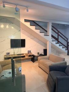 een woonkamer met een bank en een trap bij Aconchego Paracuru in Paracuru