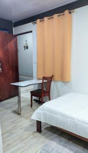 una camera da letto con un letto, un tavolo e una sedia di Cozy Studio Rohrmoser a San José