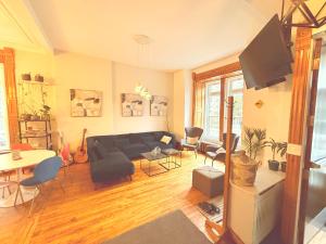 Una sala de estar con un sofá y un televisor en Auberge du Plateau, en Montreal