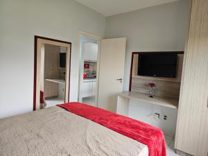 a bedroom with a bed and a flat screen tv at Frente ao Parque da Lagoa Quente Entrada NÃO INCLUSA Aptos Particulares com varanda in Caldas Novas +39 photos