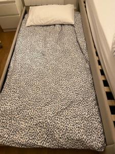 a black and white bed with a pillow on it at Listed building close to River Thames in London