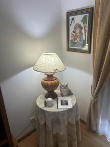einen Tisch mit einer Lampe und einem Bild darauf in der Unterkunft Alojamento Luna in Porto Judeu