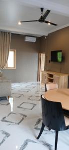 a room with a table and chairs and a television at Villa Panorama Amed in Ambat