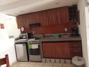 a kitchen with wooden cabinets and a stove top oven at Loft Guelaguetza B in Santa Cruz Huatulco