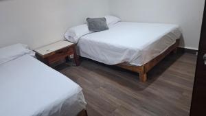 two twin beds in a room with two tables at Loft Guelaguetza B in Santa Cruz Huatulco