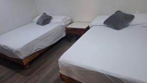 two twin beds in a room with a table at Loft Guelaguetza B in Santa Cruz Huatulco +16 photos
