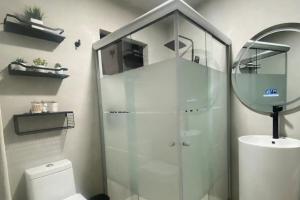 ein Bad mit einer Dusche, einem WC und einem Spiegel in der Unterkunft Casabel - Downtown Querétaro in Querétaro + 39 Fotos
