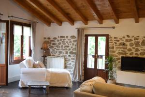a living room with a stone wall at Batxillerenea in Doneztebe
