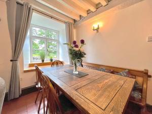 un tavolo da pranzo con un vaso di fiori sopra di 4 Bed in Betws y coed 52111 a Capel Garmon