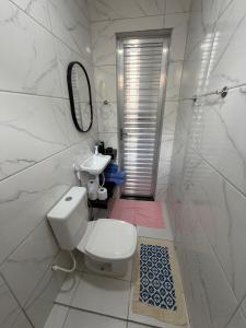 a white bathroom with a toilet and a sink at AmazHost - Casa azul próxima da Basílica de Nazaré in Belém +2 photos