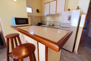 a kitchen with a counter with a microwave and a refrigerator at Los colibríes in Necochea +2 photos