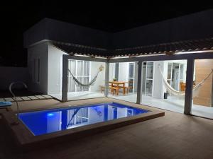 a house with a pool in the middle of a room at Refúgio do Mar in Japaratinga