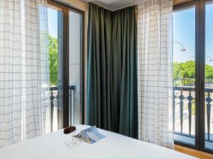 ルーアンにあるAparthotel Adagio Access Rouen Centre Cathédraleの大きな窓と白いテーブルが備わる客室です。 +109枚の写真