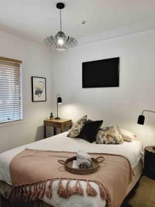 Schlafzimmer mit einem Bett und einem TV an der Wand in der Unterkunft Stay at the heart of the city! in Auckland