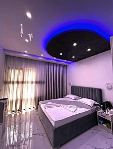 a bedroom with a bed with a purple lighting at APART-HOTEL PRESiDENT 2 in Ulcinj