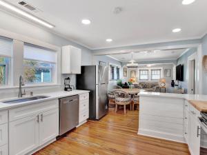 una cucina con armadi bianchi e una sala da pranzo di Ebb & Flow Apartment House a Tybee Island