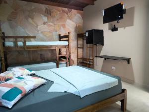 a bedroom with two bunk beds and a wall at Guaraú Surf House Chalés in Peruíbe